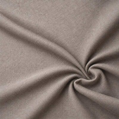 Textured upholstery fabric in light taupe laid in soft folds