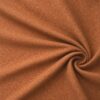 Textured upholstery fabric in terracotta laid in soft folds