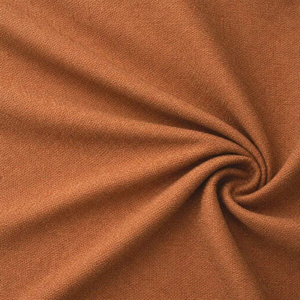 Textured upholstery fabric in terracotta laid in soft folds