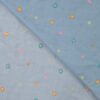 Close-up of floral embroidery on dusty blue denim look