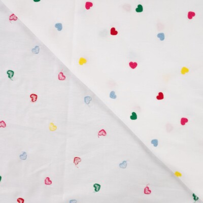 Detalje af broderi med farvede hjerter på bomuldsvoile