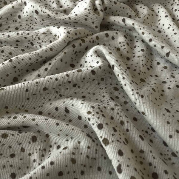 Sileä single jersey -pinta merinovilla-silkki neuloksessa pilkuilla