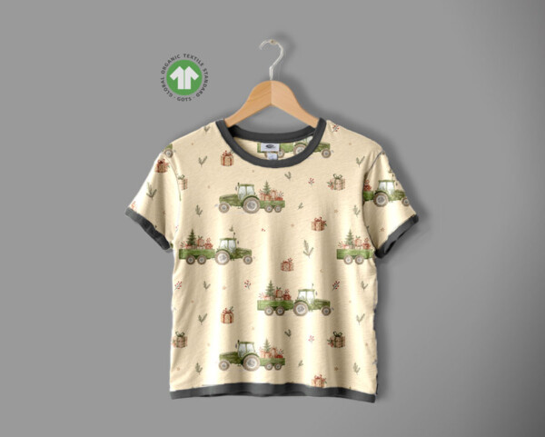 Detail of tractors and Christmas trees motif on cream cotton jersey