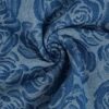 Nærbillede af rosemotiv i jeansblå denim jacquard 150 cm bred