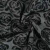 Nærbillede af rosemotiv i sort denim jacquard 150 cm bred