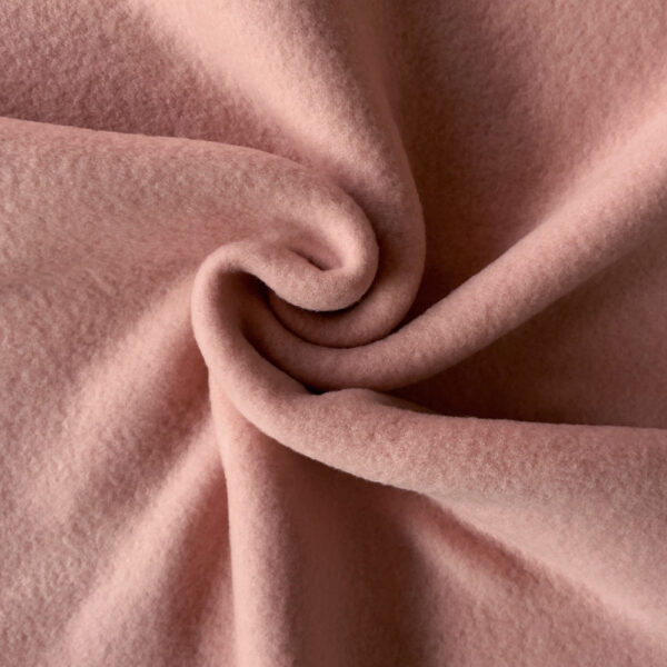 Pudderrosa merinould fleece, snoet i en spiral, så faldet ses