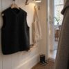 Vest in black teddy fabric on a hanger in the hallway