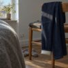Jeans in dark slub denim with fleece back over a chair