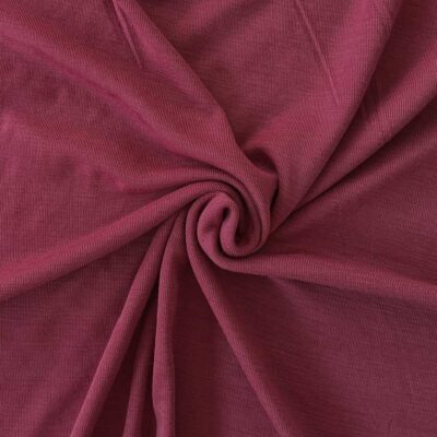 Cranberry merino wool jersey fabric, twisted into a spiral to show drape