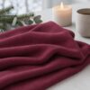 Cranberry merino wool jersey, folded in candlelight