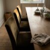 Ruokapöydän tuolit verhoiltu oliivinruskealla verhoiluveluurilla