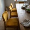 Ruokapöydän tuolit verhoiltu sinapinkeltaisella verhoiluveluurilla