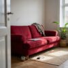 Sofa betrukket med velour i rød (AI-genereret illustration)