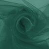 Bottle green organza arranged in soft folds, lightweight transparent fabric