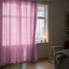 Gardin af organza i gammelrosa foran et vindue