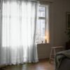 Valkoinen organza-verho ikkunan edessä