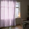 Vaaleanpunainen organzaverho ikkunan edessä