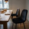 Dining chairs upholstered in black velour (AI-generated illustration)